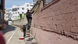 울산 염포동 주민자치위, 노후 아파트 담장 페인트칠 봉사